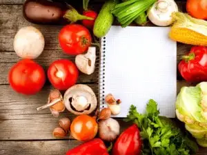 Open Notebook and Fresh Vegetables Background. Diet Open Notebook and Fresh Vegetables Background. Diet